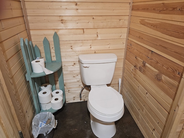 bathroom with wooden walls and toilet