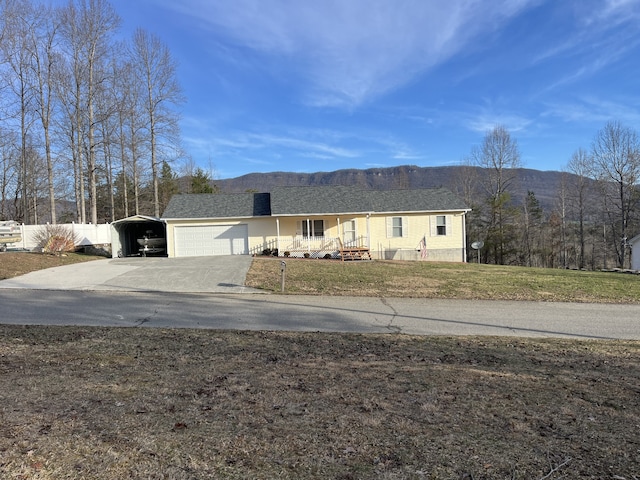 view of front facade featuring a mountain view, a front yard, and a garage