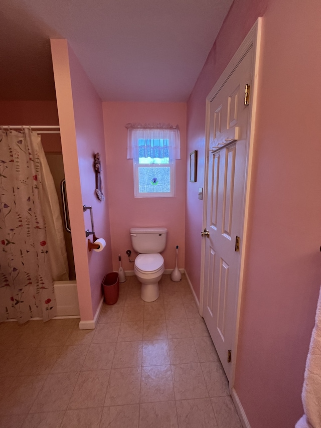 bathroom featuring toilet, shower / bath combo, and tile floors