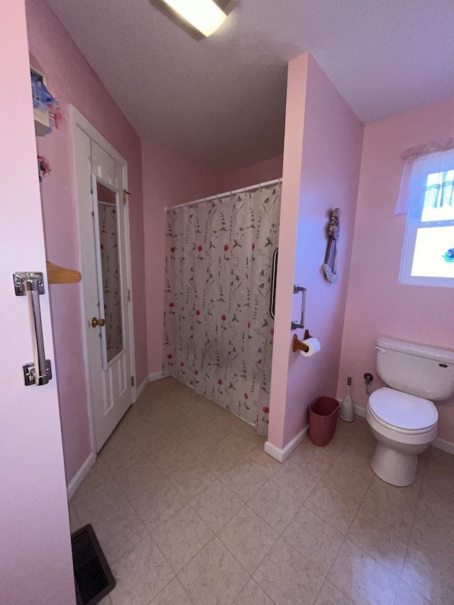 bathroom with tile floors and toilet