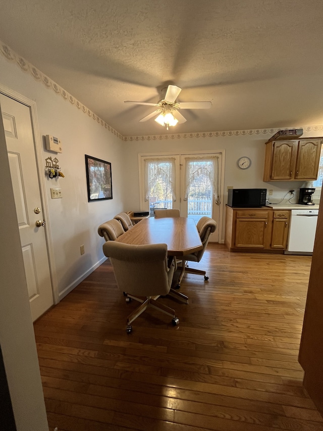 dining area featuring hardwood / wood-style floors, a textured ceiling, and ceiling fan