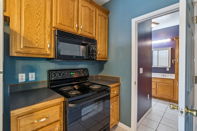 kitchen with sink, light tile floors, and black appliances