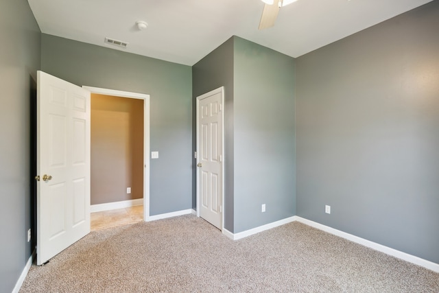 carpeted spare room featuring ceiling fan