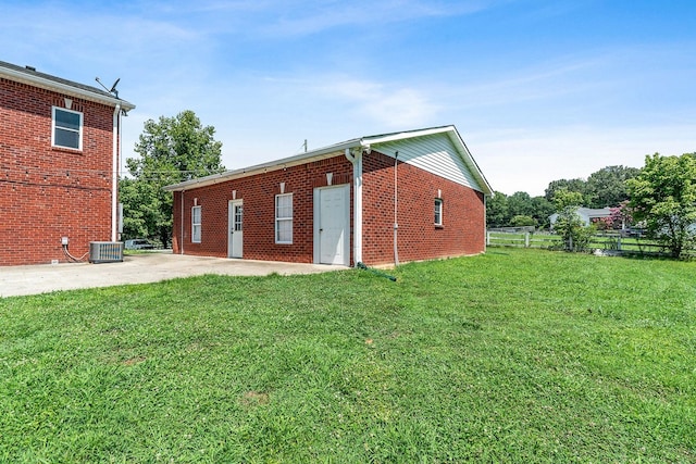 back of house with a patio, a yard, and central AC