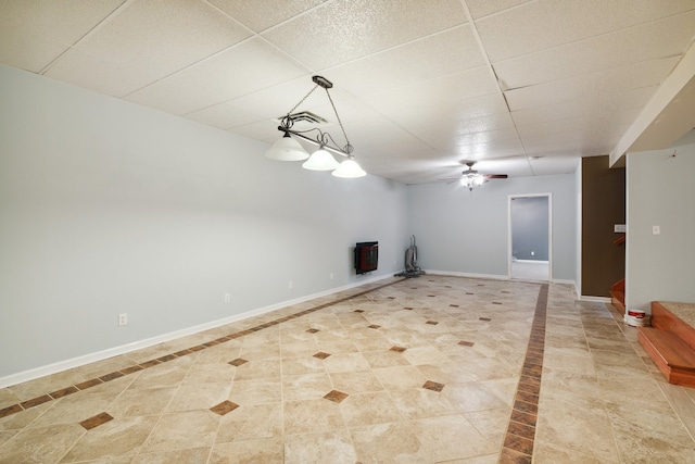 unfurnished living room with light tile floors, ceiling fan, and a drop ceiling