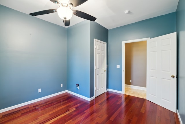 unfurnished bedroom featuring ceiling fan and dark hardwood / wood-style flooring