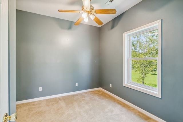 spare room with plenty of natural light, ceiling fan, and light colored carpet