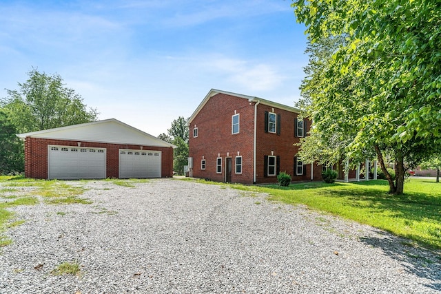 view of front of house with an outdoor structure, a front yard, and a garage