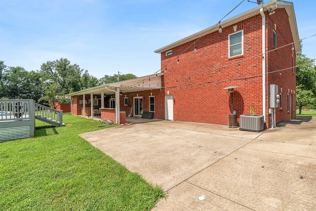 back of property with a lawn and central AC unit