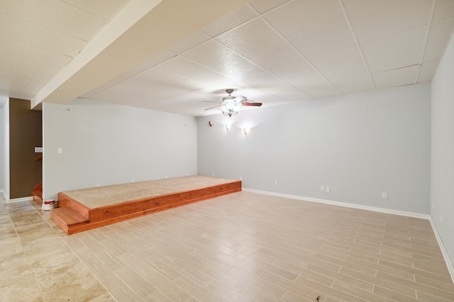 empty room featuring ceiling fan and a drop ceiling