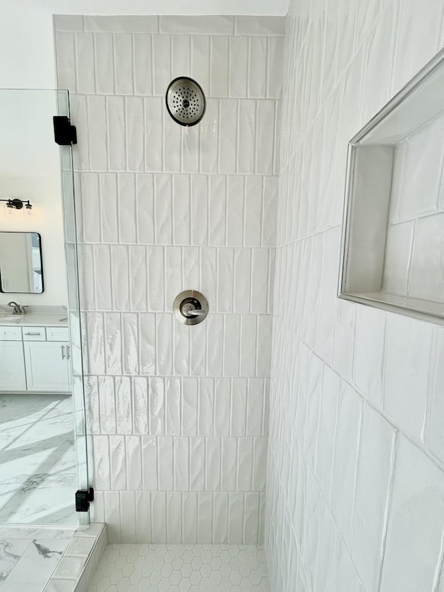 full bath with a tile shower and vanity