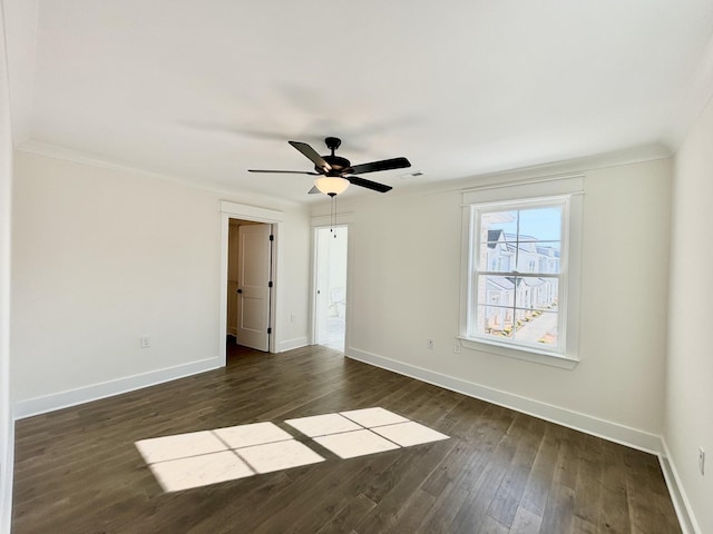 unfurnished bedroom featuring a ceiling fan, dark wood-style flooring, crown molding, and baseboards