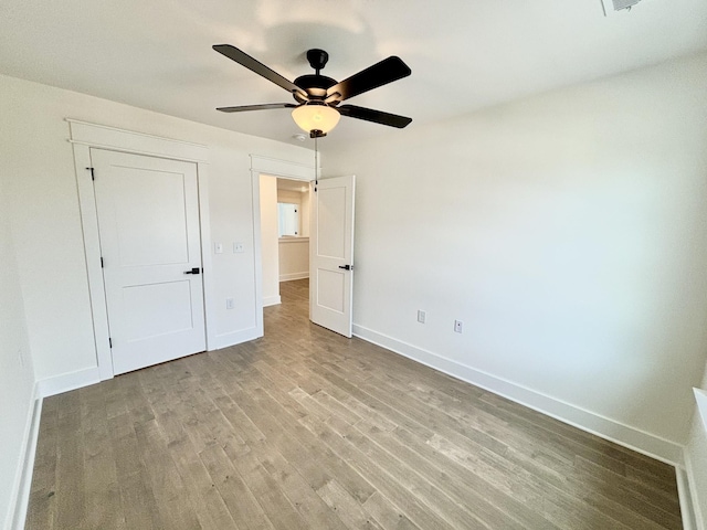 unfurnished bedroom with wood finished floors, a ceiling fan, and baseboards