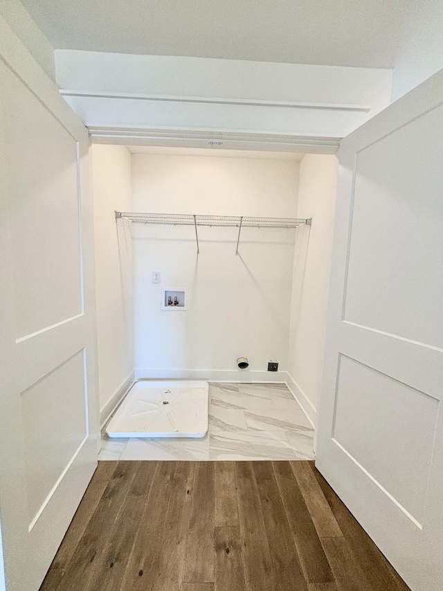 laundry room with washer hookup, laundry area, baseboards, and wood finished floors