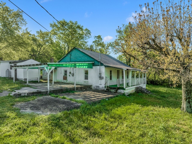 rear view of house with a yard, a porch, and a carport