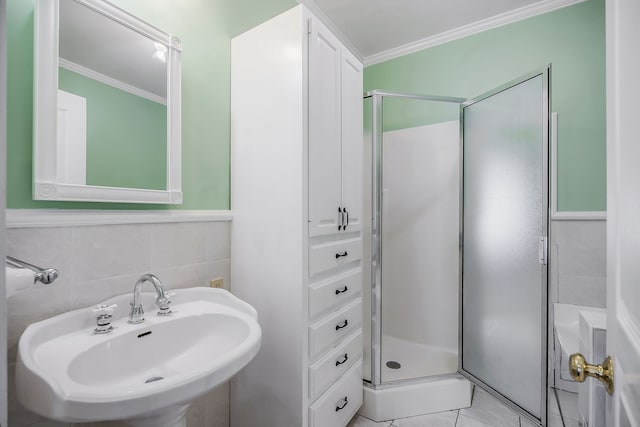 bathroom featuring tile walls, sink, crown molding, an enclosed shower, and tile floors