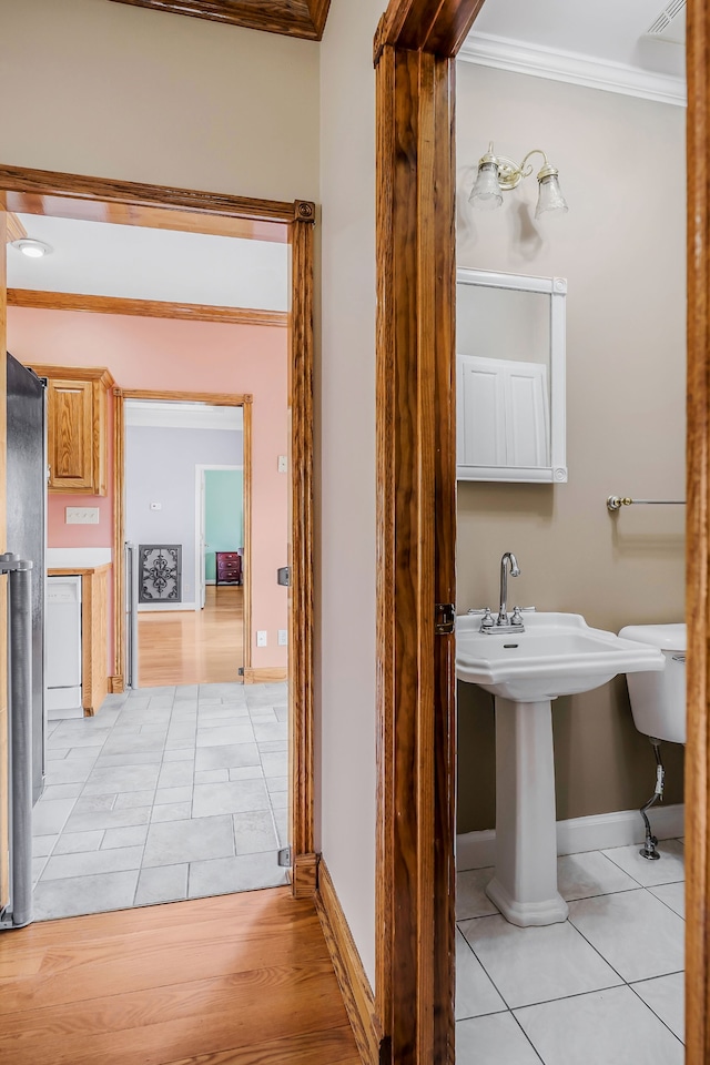 bathroom featuring crown molding, toilet, and tile flooring