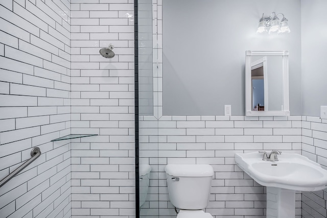 bathroom featuring tile walls, toilet, and tiled shower