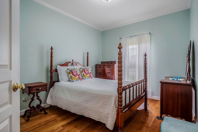 bedroom with ornamental molding and dark hardwood / wood-style floors