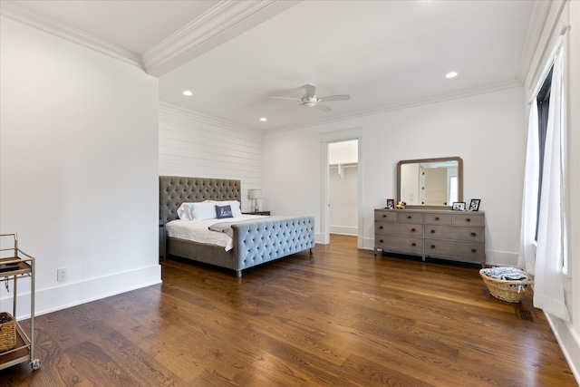 bedroom featuring ornamental molding, dark hardwood / wood-style floors, a spacious closet, a closet, and ceiling fan