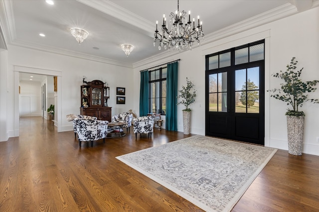 foyer featuring dark wood-type flooring, an inviting chandelier, french doors, and crown molding