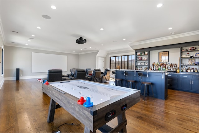 rec room with indoor bar, ornamental molding, and hardwood / wood-style floors