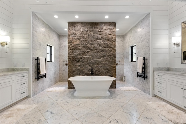 bathroom with tile flooring, vanity, ornamental molding, and tile walls