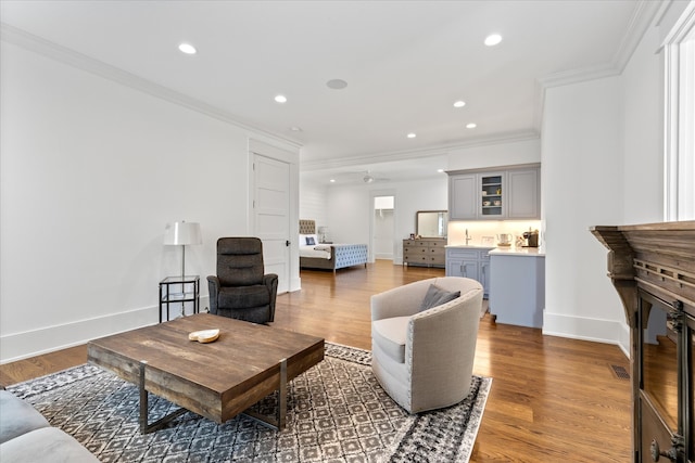 living room featuring ornamental molding, ceiling fan, and hardwood / wood-style floors