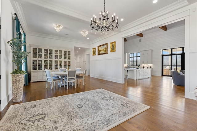 dining room featuring a chandelier, ornamental molding, and dark hardwood / wood-style flooring