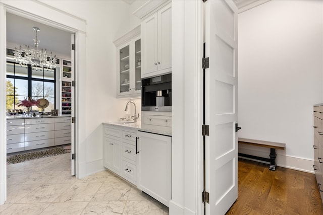 kitchen with a chandelier, wall oven, light tile flooring, white cabinets, and sink