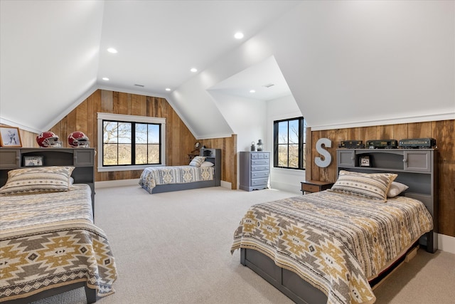 bedroom with wood walls, light carpet, and lofted ceiling