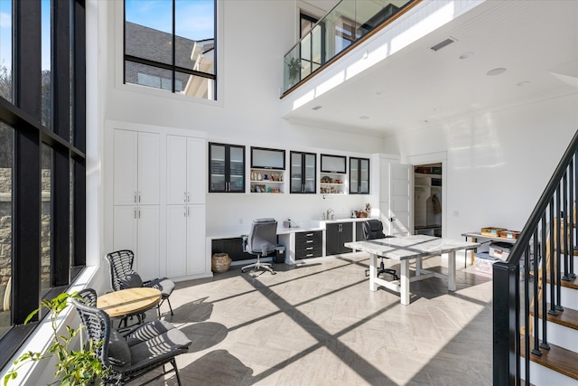 interior space with a towering ceiling and ornamental molding