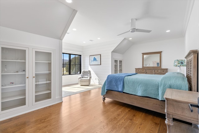 bedroom with hardwood / wood-style flooring, lofted ceiling, ornamental molding, and ceiling fan