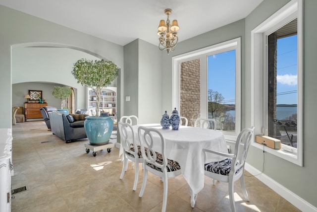 tiled dining room featuring a chandelier