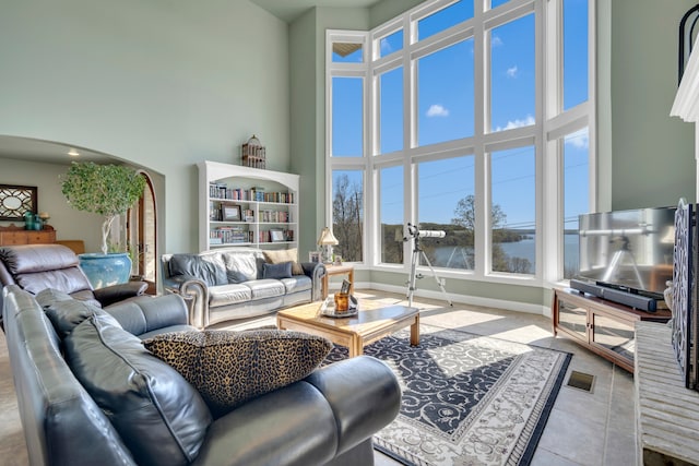 tiled living room featuring a high ceiling