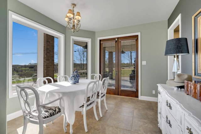 dining area with light tile floors and an inviting chandelier