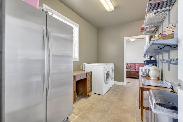 laundry room featuring light tile floors and separate washer and dryer