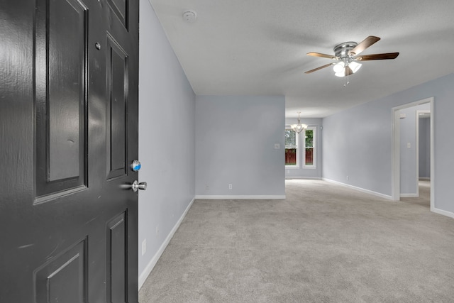 carpeted foyer with ceiling fan with notable chandelier