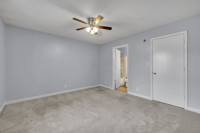 unfurnished bedroom with light carpet, ensuite bath, and ceiling fan