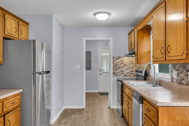 kitchen featuring stainless steel appliances, backsplash, light hardwood / wood-style floors, sink, and a healthy amount of sunlight