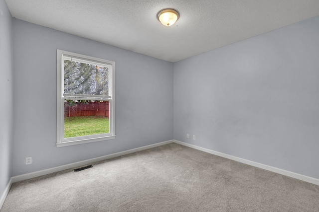 carpeted empty room with a textured ceiling