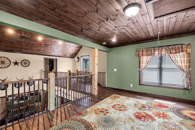 unfurnished room featuring a skylight, wood ceiling, and dark hardwood / wood-style floors