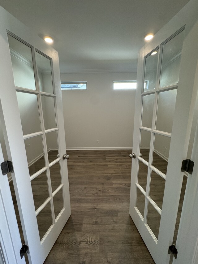 walk in closet with french doors and wood finished floors