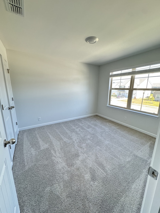 unfurnished room with baseboards, visible vents, and carpet flooring