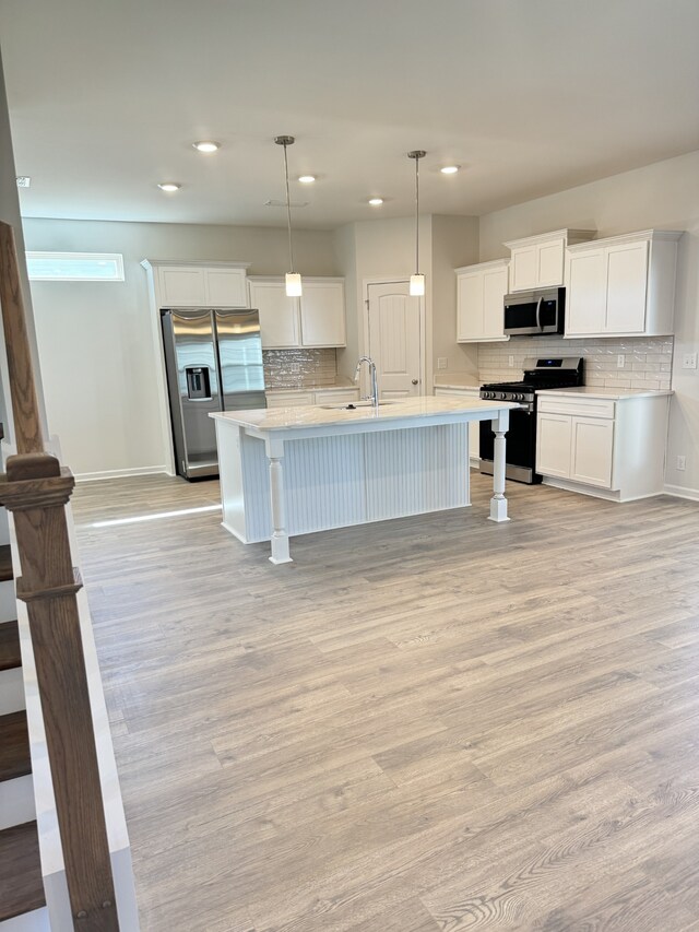 kitchen featuring light wood-type flooring, a sink, stainless steel appliances, and light countertops