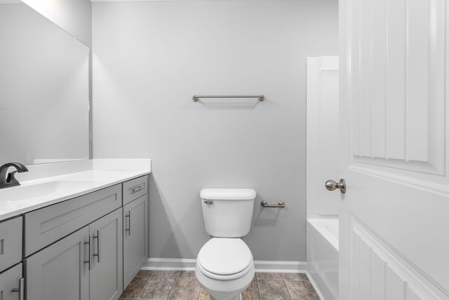 full bathroom with vanity, baseboards, a bathing tub, tile patterned flooring, and toilet