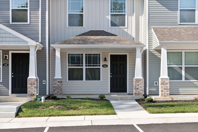 property entrance featuring covered porch, board and batten siding, and a shingled roof