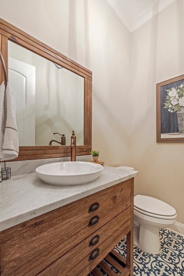 bathroom with tile floors, crown molding, toilet, and vanity