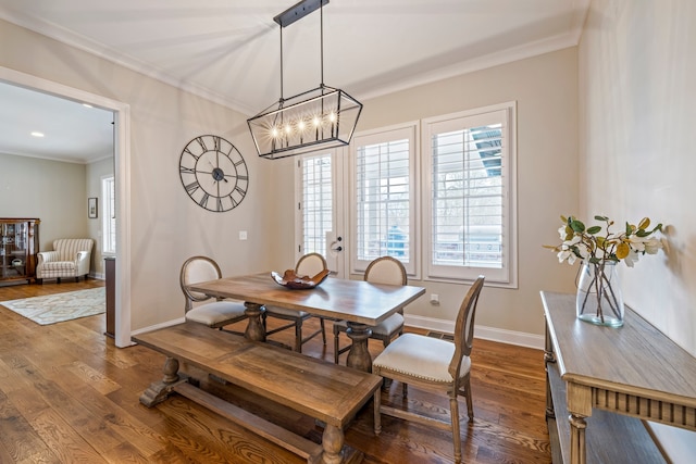 dining room featuring dark hardwood / wood-style floors, ornamental molding, a healthy amount of sunlight, and an inviting chandelier