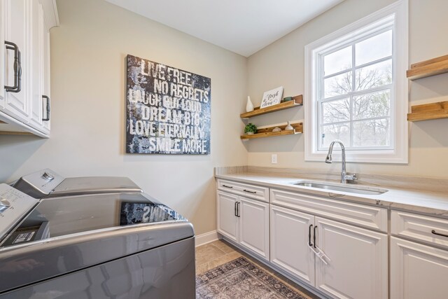 washroom featuring dark tile floors, cabinets, sink, and independent washer and dryer